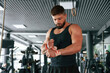 © standret - Red protective bandages on hands. Strong muscular man is working out in the gym