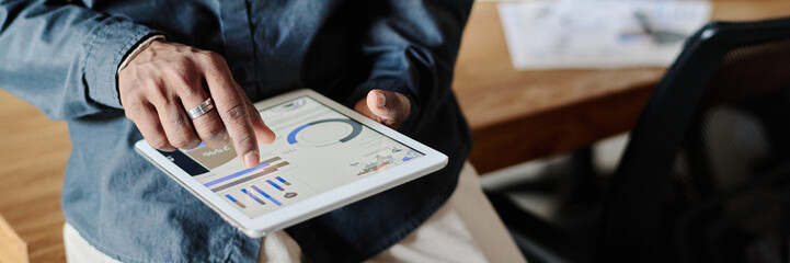 Wall Mural - Website header shot of unrecognizable male hands holding tablet with launched app showing recent analytical analysis