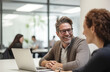 © Minimal Blue - Smiling Businessman Engaging In Friendly Conversation With Colleague In Bright Office Space