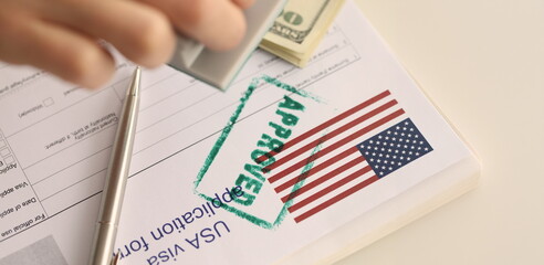 Close-up of USA visa approved, application form for emigration abroad. Visa approved with rubber stamp, american flag. Embassy and immigration services