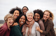 © Minimal Blue - Diverse Group of Women of All Ages Smiling and Embracing Each Other in a Joyful Outdoor Setting