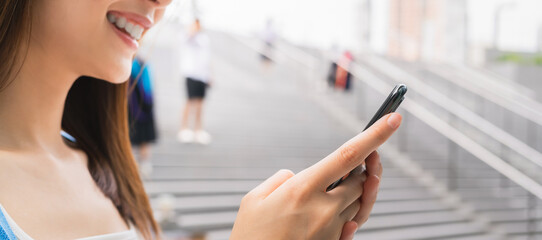 Wall Mural - woman using smartphone in public areas, During leisure time. The concept of using the phone is essential in everyday life.