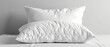© Nattagid - Two fluffy white pillows on a bed with a minimalist aesthetic, offering comfort and style for any bedroom decor.