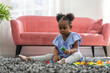 © Art_Photo - Young african girl playing with colorful building blocks joy creativity, child fully engrossed in her playtime, innocence and concentration of early childhood, learning, play and family life