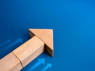 Poster - Leader, wooden cube block arranged as a big heading arrow with white small arrows, isolated on blue background with copy space. Business strategy with growth success process, leadership concept.