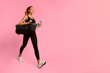 Canvas Print - Fitness. Joyful Young Lady Carrying Bag With Mat And Bottle Of Water Going To Gym Over Yellow Studio Background