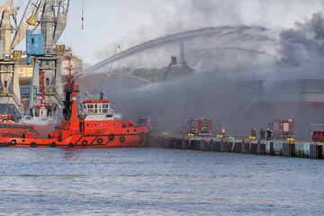 Wall Mural - A fire in a warehouse in which a toy wholesaler caught fire. The fire was extinguished by firefighting vessels and fire brigade units, Port of Gdansk, Gdansk, Poland. date of destruction July 14, 2024