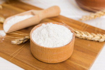 Wall Mural - Flat lay of Wheat flour in wooden bowl with wheat spikelets on colored background. world wheat crisis