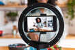 © Westend61 - Woman standing in kitchen filming cooking tutorial