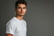 © furyon - confident young man in crisp white tshirt striking a casual pose against a minimalist gray backdrop studio lighting creating subtle shadows