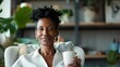 © svastix - A woman with natural hair smiles warmly while holding a mug in a cozy living room setting with greenery and comfortable furniture, conveying relaxation and comfort.
