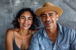 © CogniLens - Portrait of a content multicultural couple in their 30s donning a classic fedora while standing against minimalist or empty room background