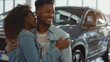 © VK Studio - A happy couple embraces in a car showroom, showcasing their excitement and joy as they stand near a new vehicle in a modern, bright space.