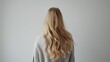 © Emin - Blonde haired young woman seen from behind on a white background