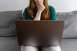 © Alina - A girl sits pensive at her laptop on the couch. Working atmosphere