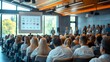 © Stone Story - Large audience attending a business conference or seminar in a modern conference room with a presenter and a projector screen.