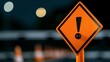 © Stone Story - Close-up of a caution sign with an exclamation mark against a blurred background, symbolizing warning, alert, or safety measures.
