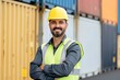 © Pist L. - Confident Male Engineer Smiling in Uniform Against Industrial Shipping Containers Background