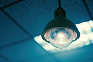 Poster - A close-up of a single hanging light fixture with a glass cover. AI.