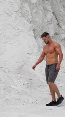 Wall Mural - Sexy model posing on nature. Young shirtless athletic man walking on mountain Vertical video