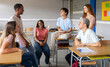 © gonzagon - Group of multi-ethnic students talking in class during a break. High school, back to school, diverse students