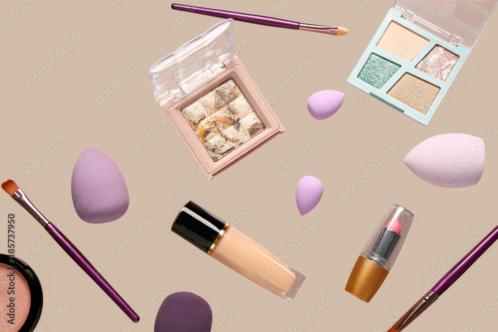 Flying decorative cosmetics on beige background