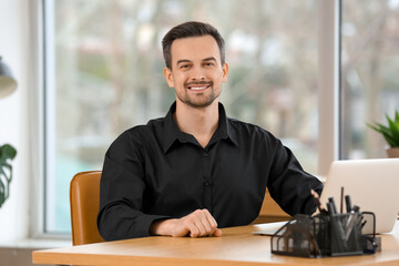 Canvas Print - Handsome businessman sitting at table in office