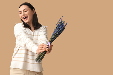 Poster - Beautiful happy young woman with bouquet of lavender flowers on beige background