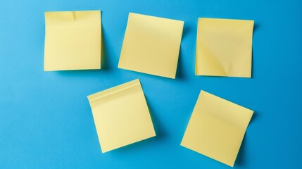 Five yellow sticky notes on a bright blue background, arranged in a row, ready for reminders or creativity.