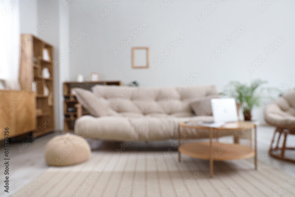 Stylish interior of light living room with sofa and coffee table, blurred view