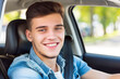 © Виктория Марьенко - A young male driver enjoys a sunny day behind the wheel, smiling inside his car