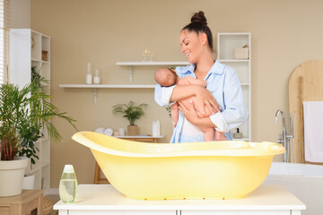 Sticker - Beautiful young happy mother with cute little baby before bathing at home