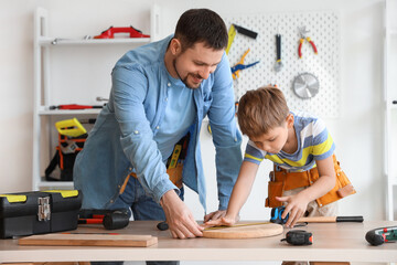 Canvas Print - Happy father and his little son with different instruments assembling wooden furniture at home