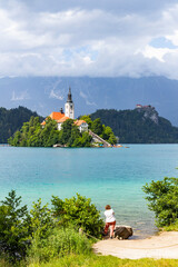 Wall Mural - Panoramic view from Lake Bled, beauty heritage in Slovenia. Island with church and castle in the background create a dream setting. View from Ojstrica and Mala Osojnica with the heart-shaped bench.