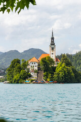 Wall Mural - Panoramic view from Lake Bled, beauty heritage in Slovenia. Island with church and castle in the background create a dream setting. View from Ojstrica and Mala Osojnica with the heart-shaped bench.