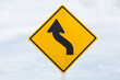© odinz - Left curve warning sign is on sky background.