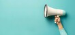 © MD - Hand Holding Megaphone on Pastel Blue Background