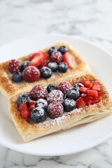 Canvas Print - Tasty puff pastries with berries on white marble table, closeup