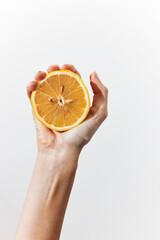 Poster - Person holding an orange fruit slice on white background