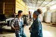 © Marko Geber - Two female farmers discussing inside tractor shed