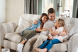 © Chanelle2000/peopleimages.com - Parents, girl and happy on sofa with hug, conversation or funny story for bonding, care and love in lounge. Father, mother and daughter with embrace, laugh and memory with connection in family home