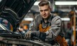 © Q STOCK - Attractive confident male auto mechanic working in Car Service