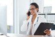 © Chanelle2000/peopleimages.com - Woman, doctor and phone call with computer in clinic for medical results, appointment schedule or virtual advice. Medicine, clipboard or telehealth with online consultation, checkup and happy to help
