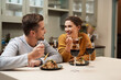 © peopleimages.com - Happy, couple and eating food in home with wine on date night for romance in relationship with bonding. Man, woman and together with dinner or alcohol in kitchen with love, trust and soul connection.