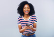 © peopleimages.com - Studio, portrait and happy woman with mobile app for chat, laugh and online connection with contact. Female person, social media and cellphone with technology, gossip and message by gray background