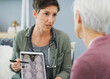 © Daniel L�/peopleimages.com - Woman, doctor and brain scan with tablet, xray and MRI results in hospital with surgery planning. Healthcare, senior and medical advice for dementia test with professional and wellness consultation