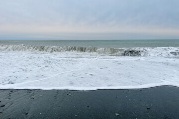 Wall Mural - beautiful sea beach with black sand and cloudy sky. weather background