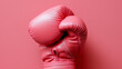 © Curioso.Photography - Pink boxing glove isolated against a matching pink background.