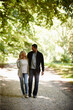 © Daniel L�/peopleimages.com - Always by each others side. Full length shot of a young couple walking arm in arm in a park.