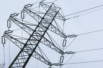 high voltage steel metal pole on a background of the blue cloudy sky